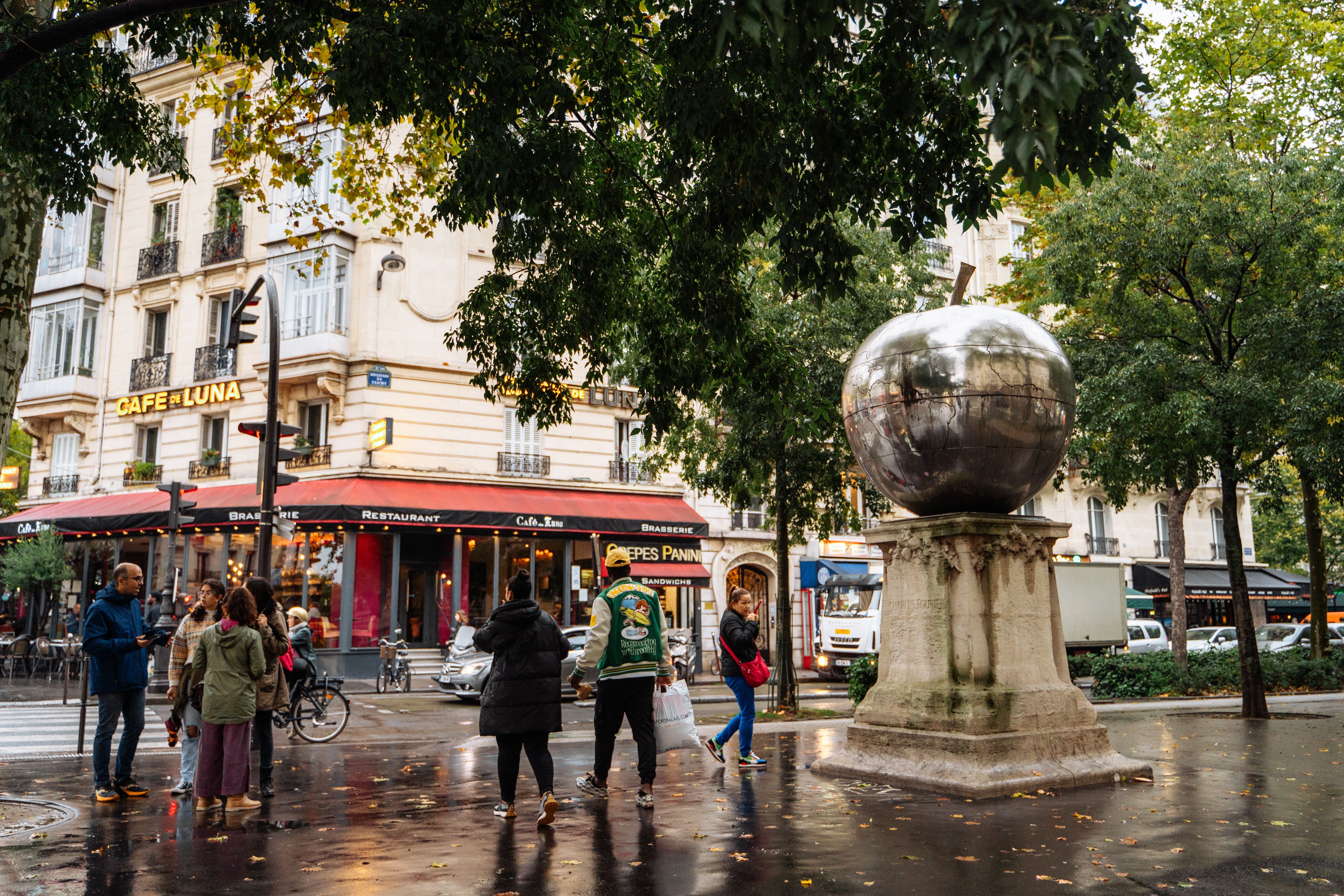 parisian street scene with cafe and sculpture