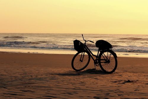 Free Silhouette of a bicycle at sunset on Guaratuba Beach, Paraná, Brazil. Stock Photo