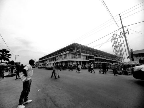 Free Black and white city street with people near a building under construction. Stock Photo