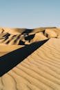 阳光明媚的沙丘在晴朗的天空下展现出迷人的景色，彰显了大自然的美丽