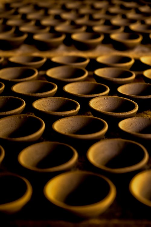 Free A row of handcrafted clay pottery with a warm, artistic touch, casting earthy shadows. Stock Photo