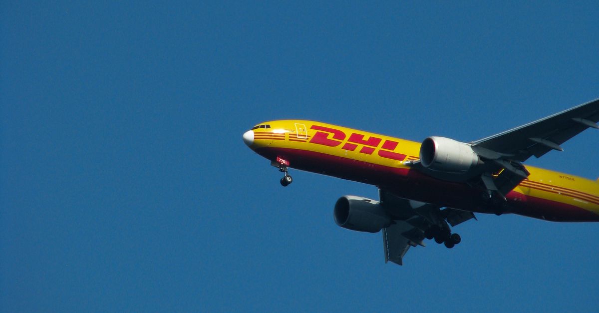 Cargo plane in flight against a clear blue sky, representing air freight transportation