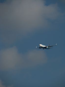 Photo by Fernando da Silva A commercial airplane mid-flight against a blue sky filled with clouds.