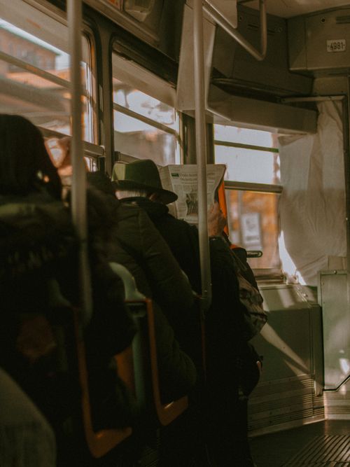 Free Passengers on a vintage tram, immersed in reading newspapers, capturing a nostalgic moment in public transportation. Stock Photo