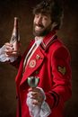 Man Wearing Red and Black Military Suit Holding Gray Steel Flute Glass