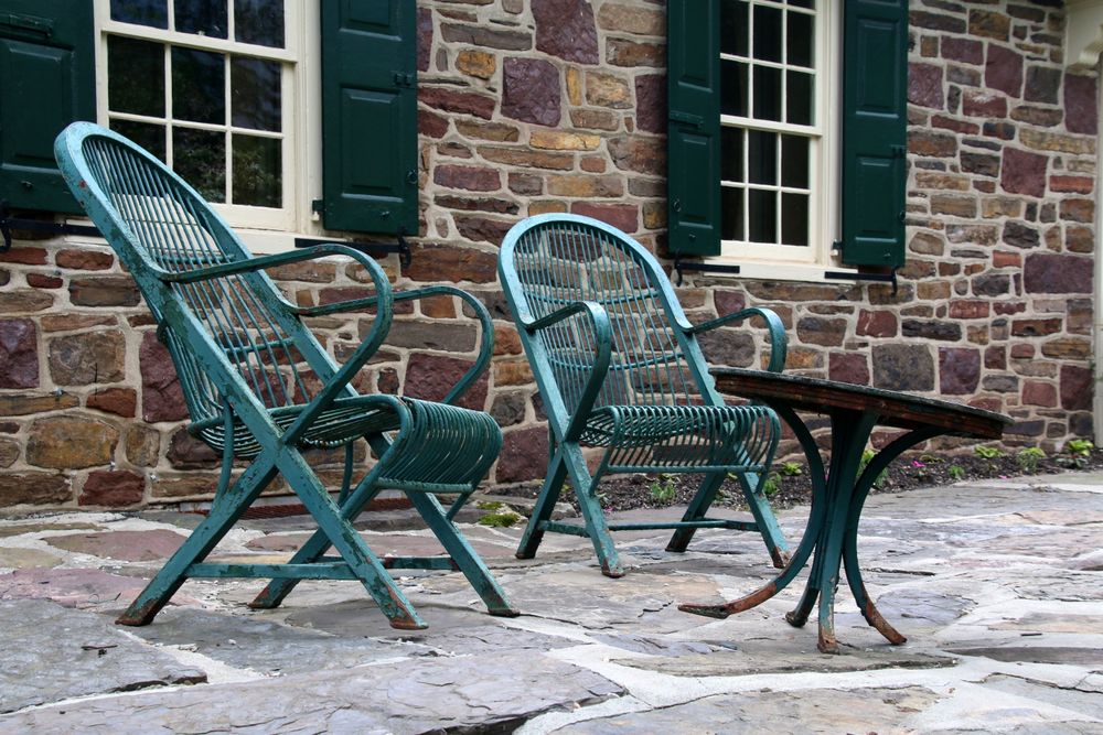 Terrace chairs beside a stone wall, photo by Gene Samit on Pexels