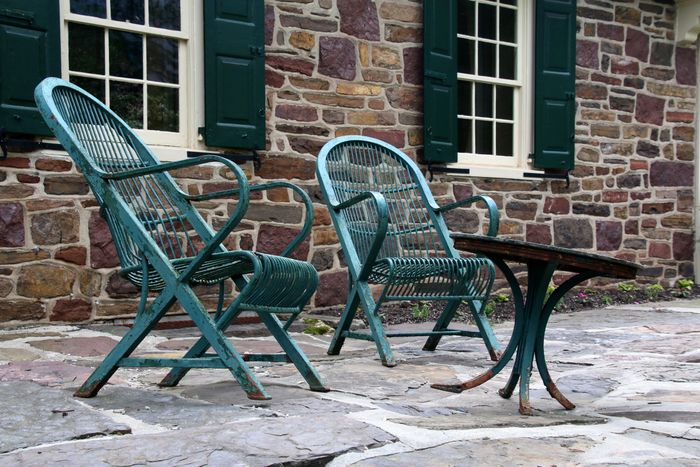 Terrace chairs beside a stone wall, photo by Gene Samit on Pexels