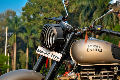 Free Close-up of a Royal Enfield motorcycle with lush greenery backdrop in Begusarai, India. Stock Photo