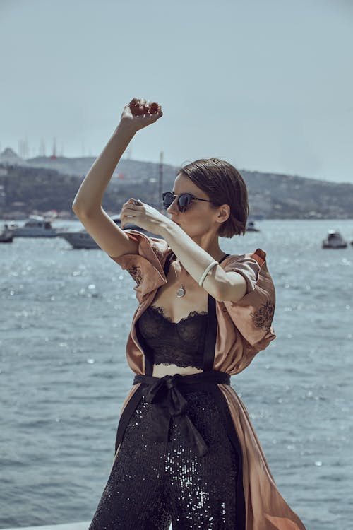 Free Woman Wearing Sunglasses While Raising Her Both Arms Stock Photo