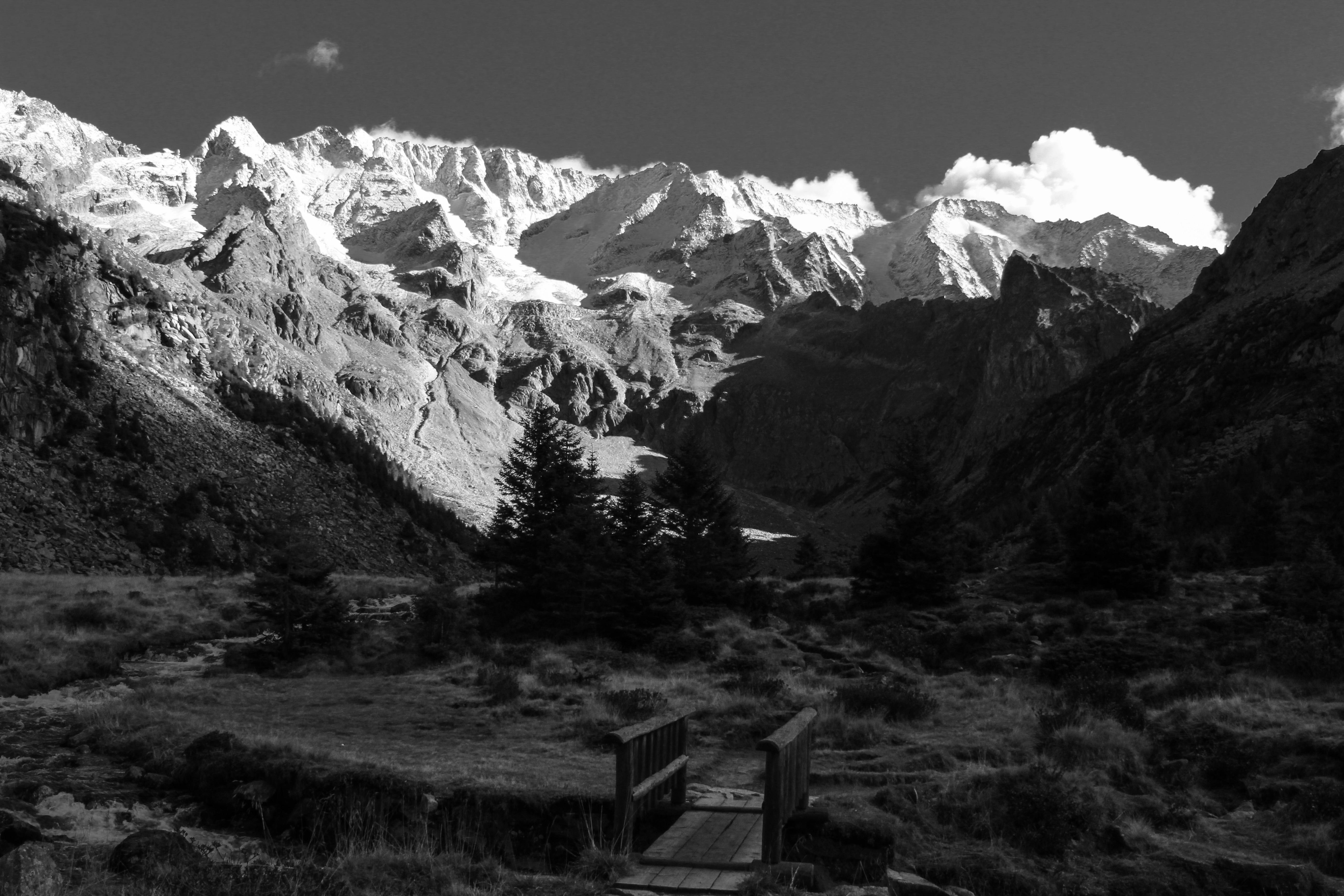 Dramatic black and white view of majestic snow-covered mountains with clear sky.