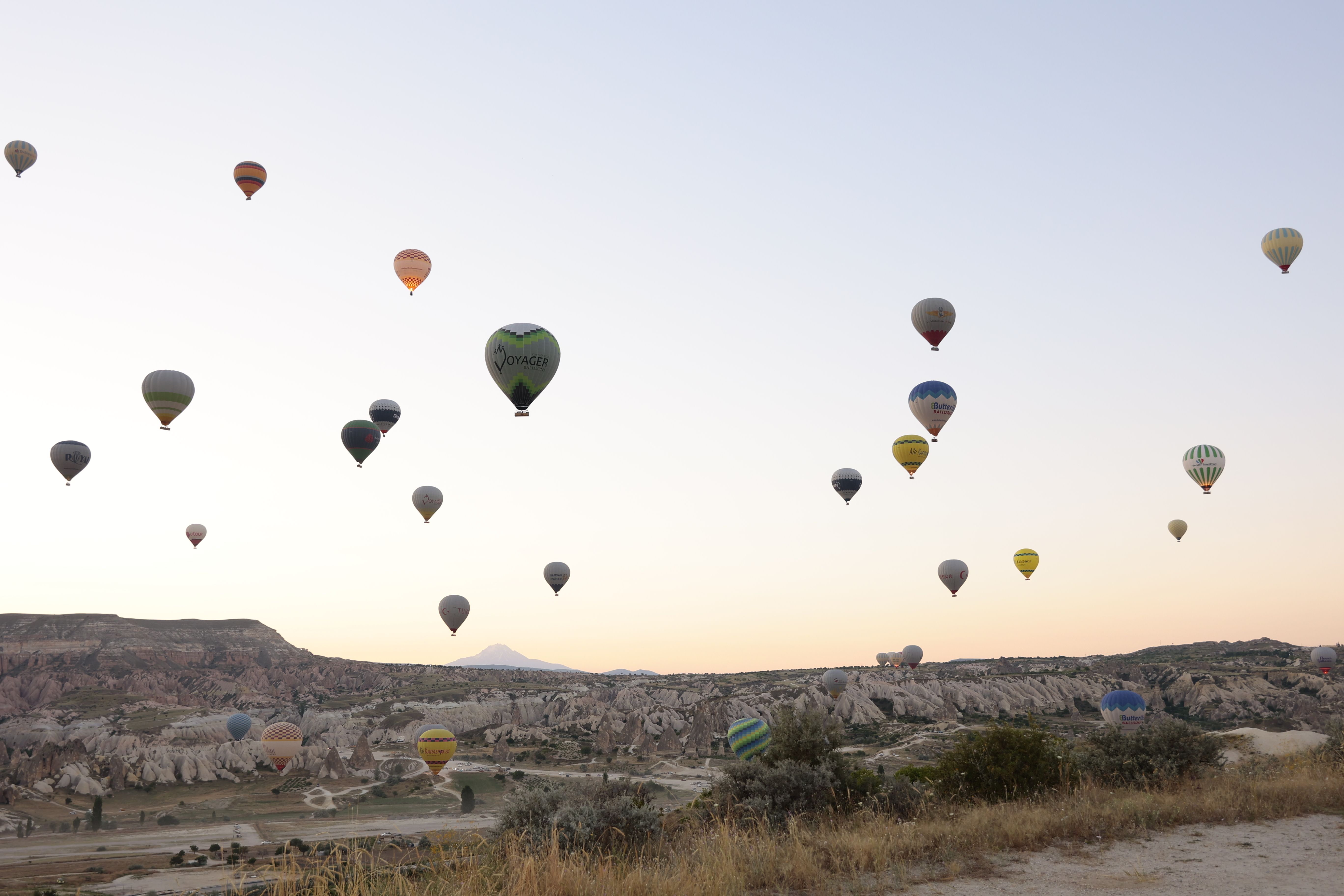 Enchanting view of hot air balloons floating over Göreme's rocky landscape at sunrise, Türkiye. Enchanting view of hot air balloons floating over Göreme's rocky landscape at sunrise, Türkiye.