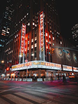 Iconic Radio City Music Hall illuminated at night in vibrant New York City.