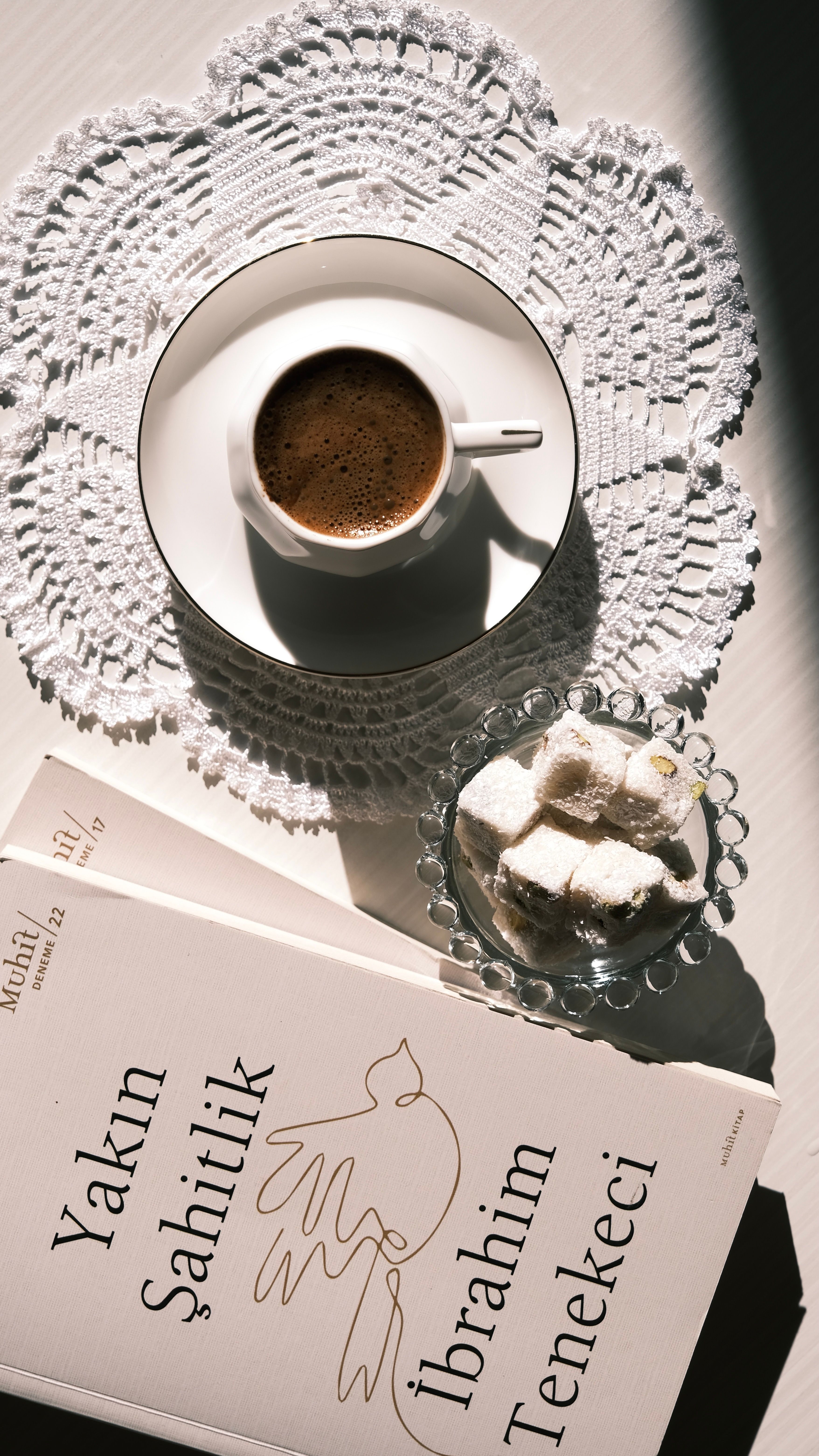 A cup of Turkish coffee alongside a book and Turkish delight, perfect for relaxation.