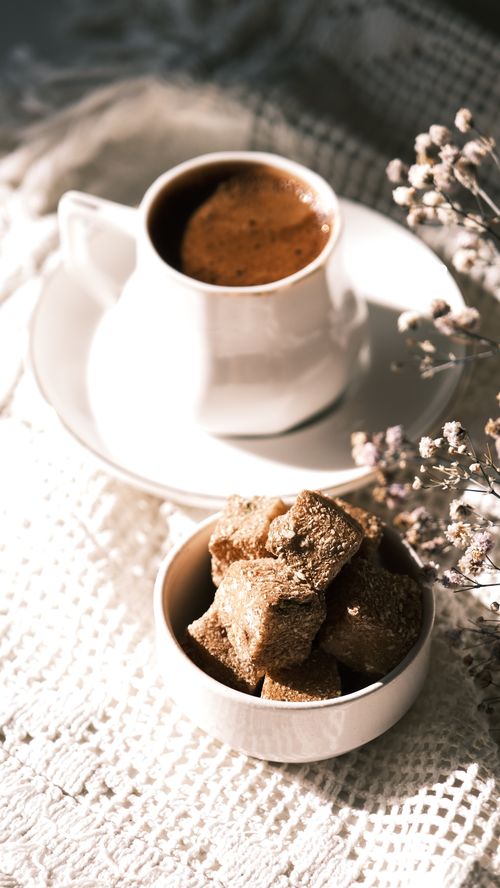 Free A delicate scene with coffee and sugar cubes on a lace surface, capturing a warm morning mood. Stock Photo