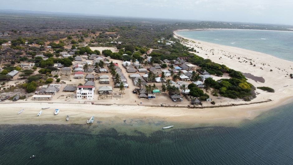 A stunning aerial shot of a coastal village in Lamu County, Kenya, featuring sandy beaches and clear ocean waters.