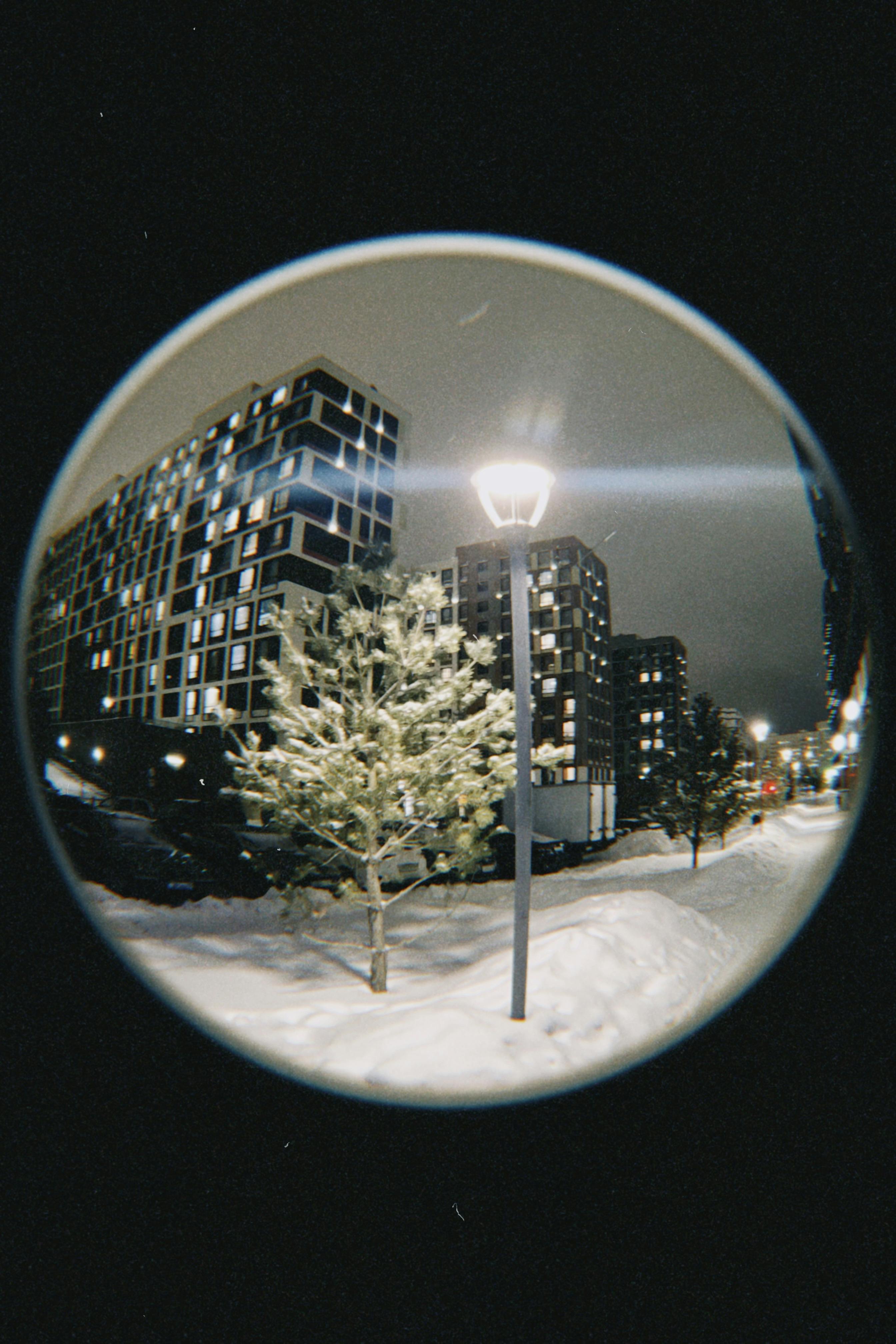 Snowy urban nightscape in Astana, Kazakhstan with modern buildings and streetlights.