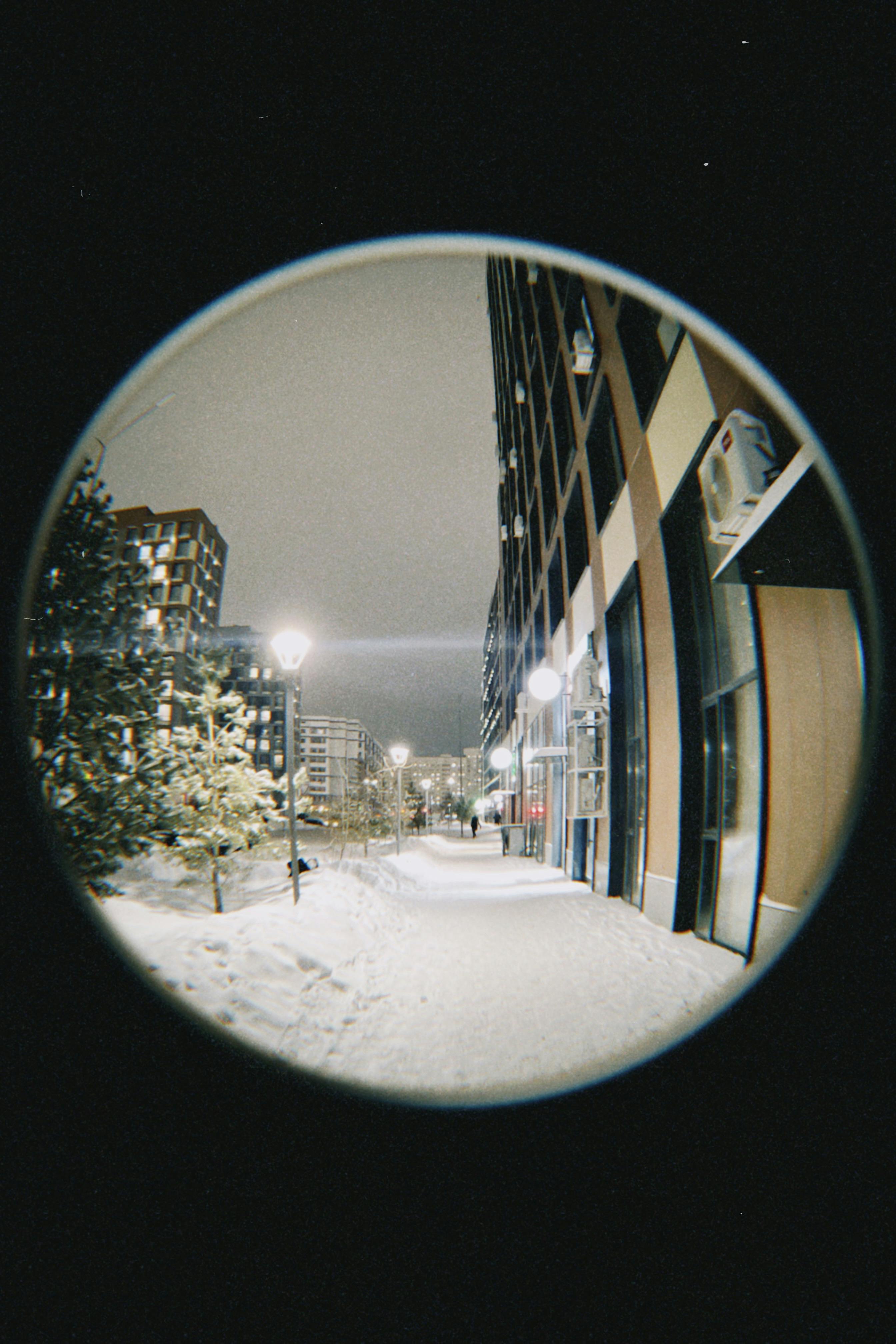 Fisheye view of a snowy street at night in Astana, Kazakhstan. Modern urban architecture.