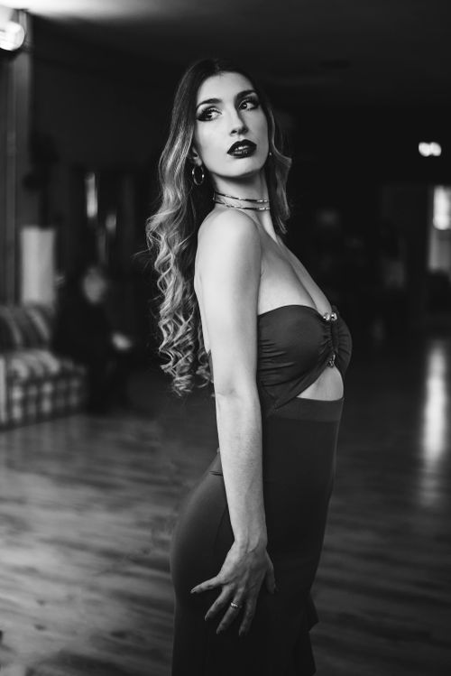 Free Stylish woman in a seductive pose captured in a black and white indoor setting. Stock Photo