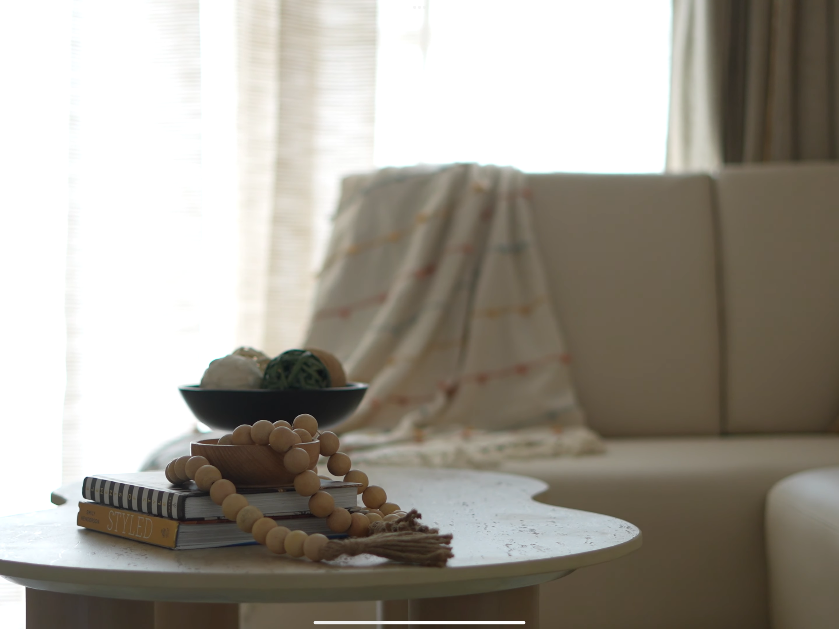 Person sitting on a minimalist couch in Bangalore with simple decor and clutter-free coffee table