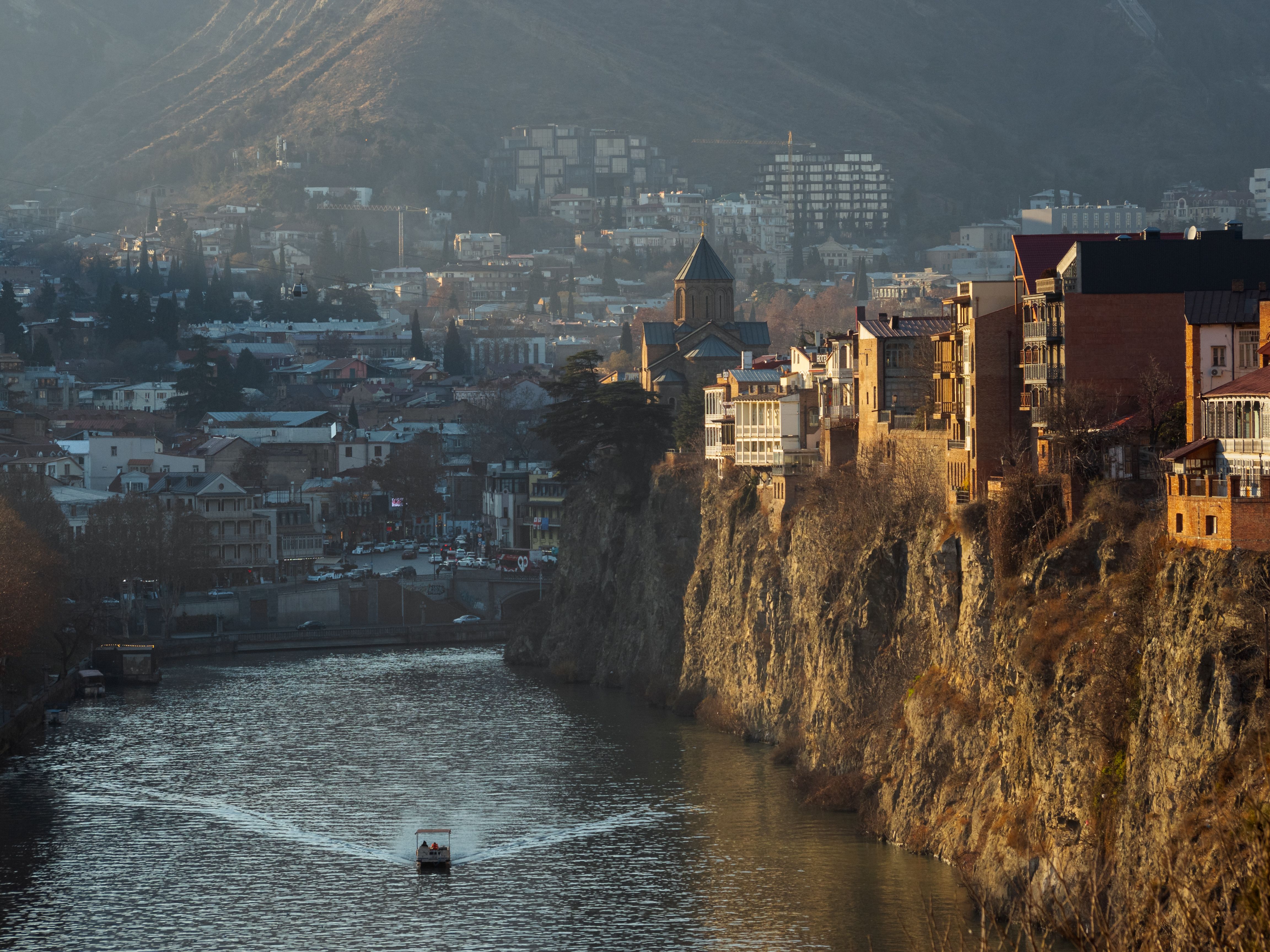 A stunning view of Tbilisi with the historic Mtkvari River and iconic architecture.