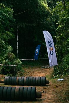 Pathway with CEAT flags in a lush forest environment, highlighting an event setup.