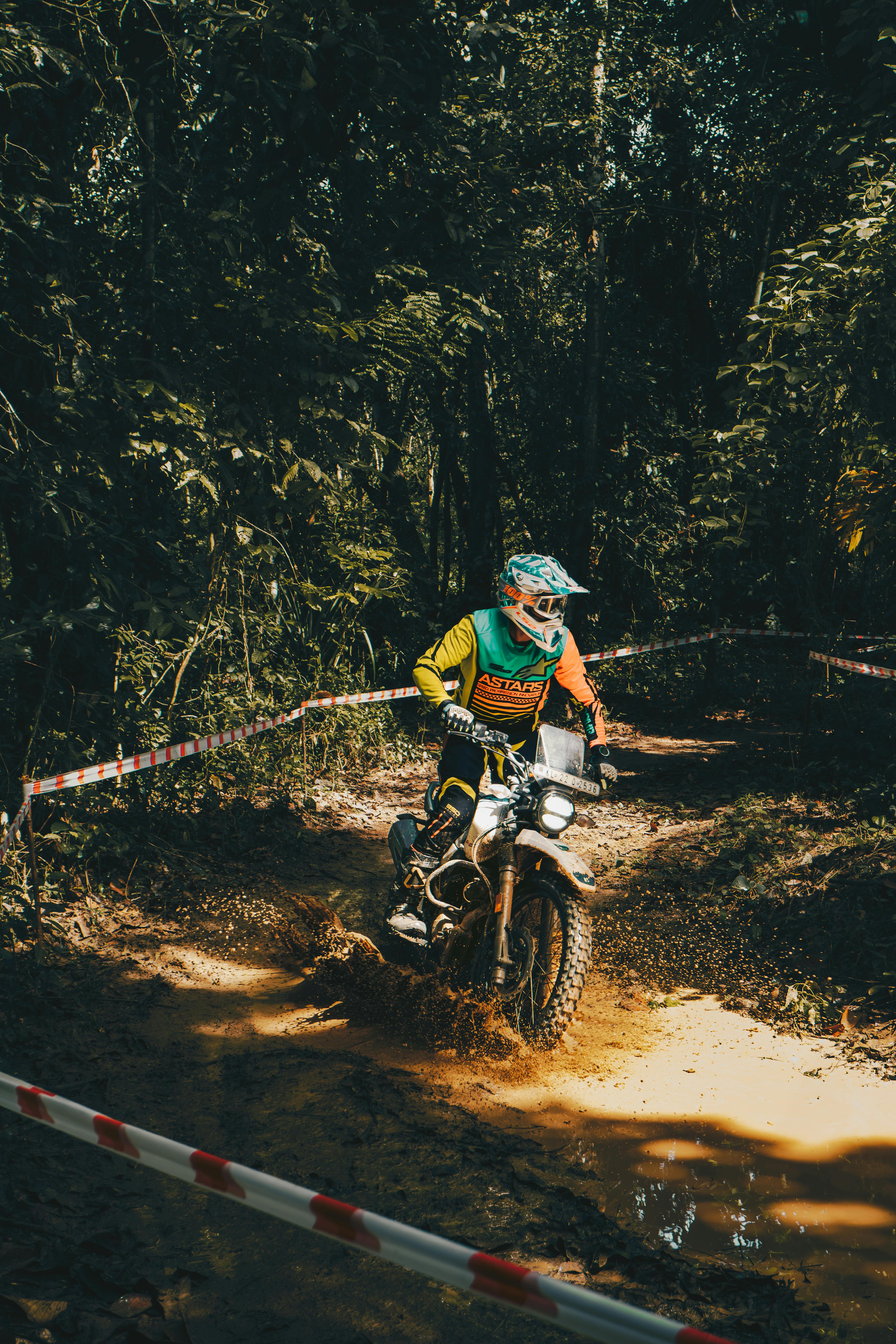 Piloto de enduro acelerando em trilha de lama