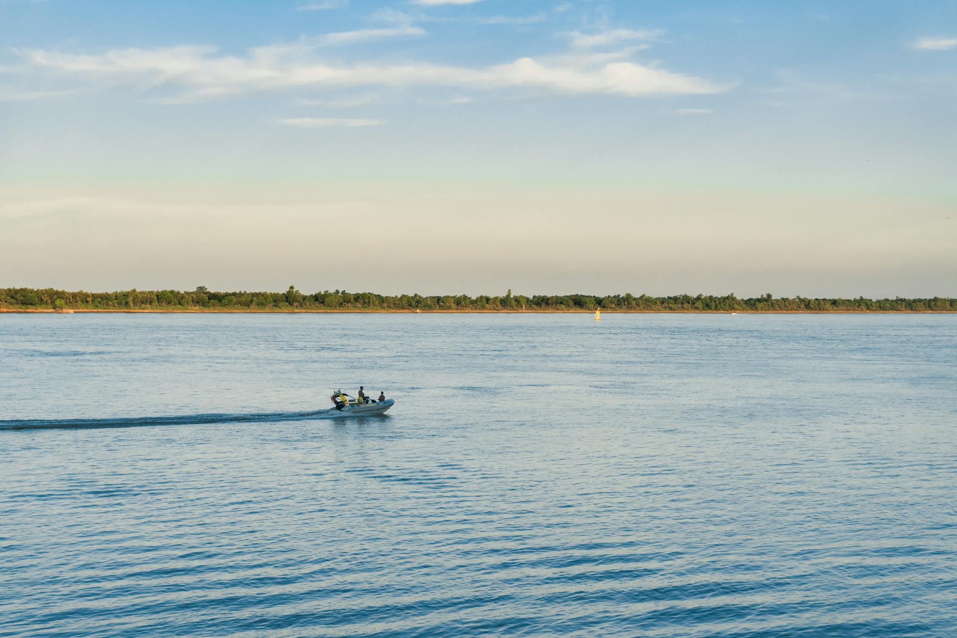 A speedboat cruising on the Paraná River near Rosario, capturing a serene summer moment.