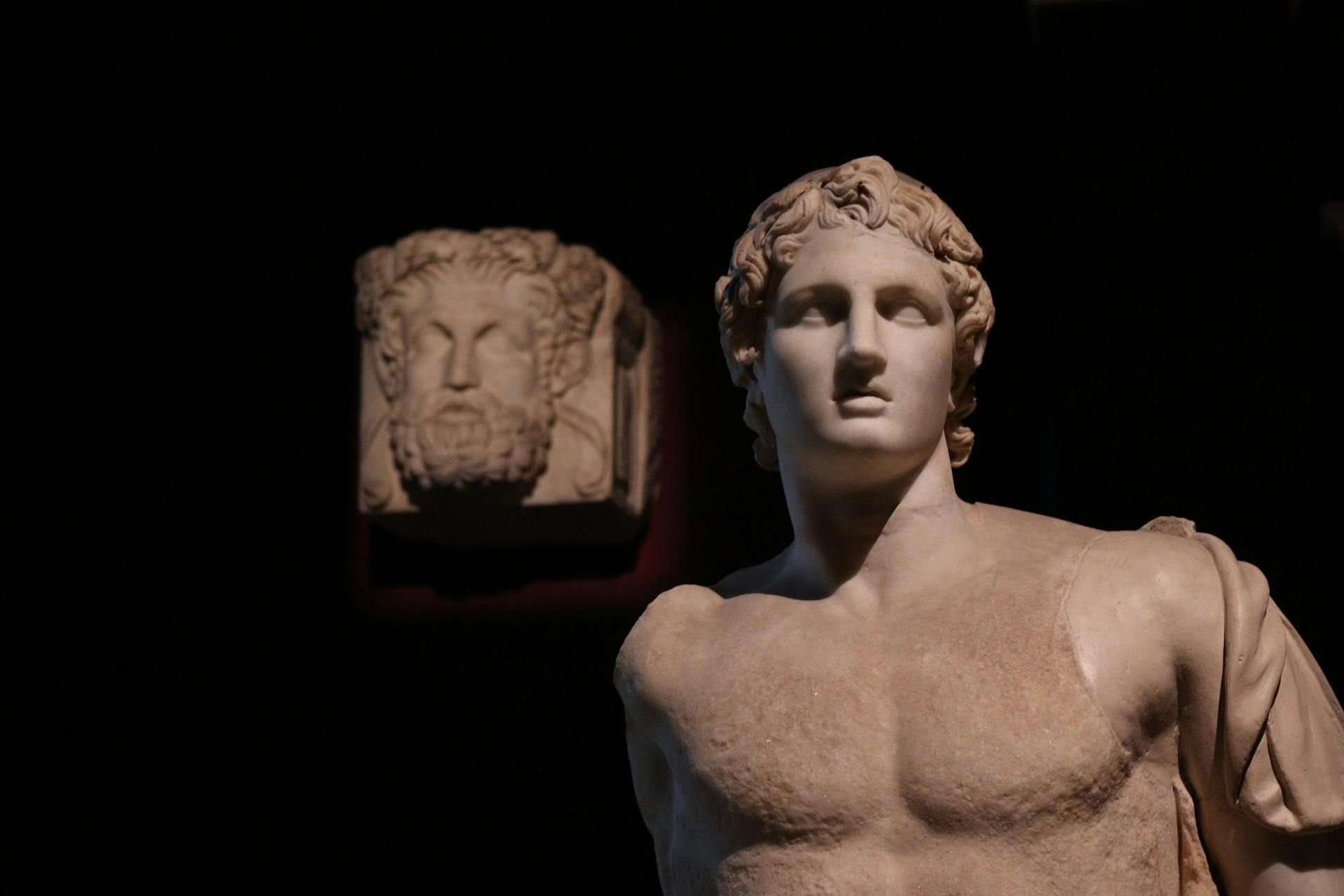 Elegant Greek statue in dramatic lighting, showcasing ancient art's timeless allure.