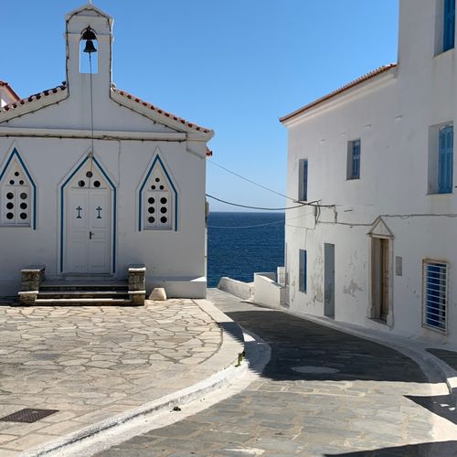 Free Traditional white chapel by the sea in a picturesque coastal village on a bright summer day. Stock Photo
