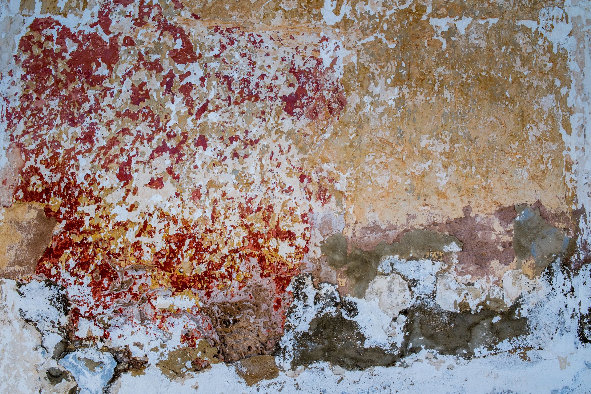 Vibrant, worn wall with abstract peeling paint in tones of red, yellow, and white.