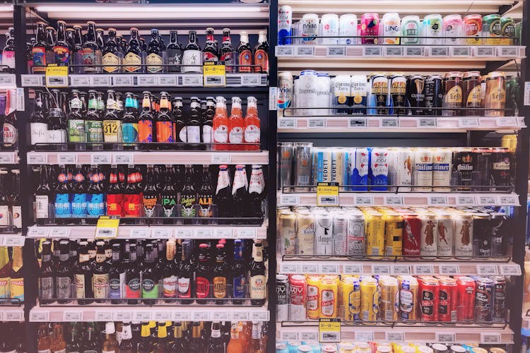 Assorted Bottles And Cans In Commercial Coolers