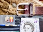 钱包的详细图像中包含了信用卡、皮带和货币，突出了个人理财的主题