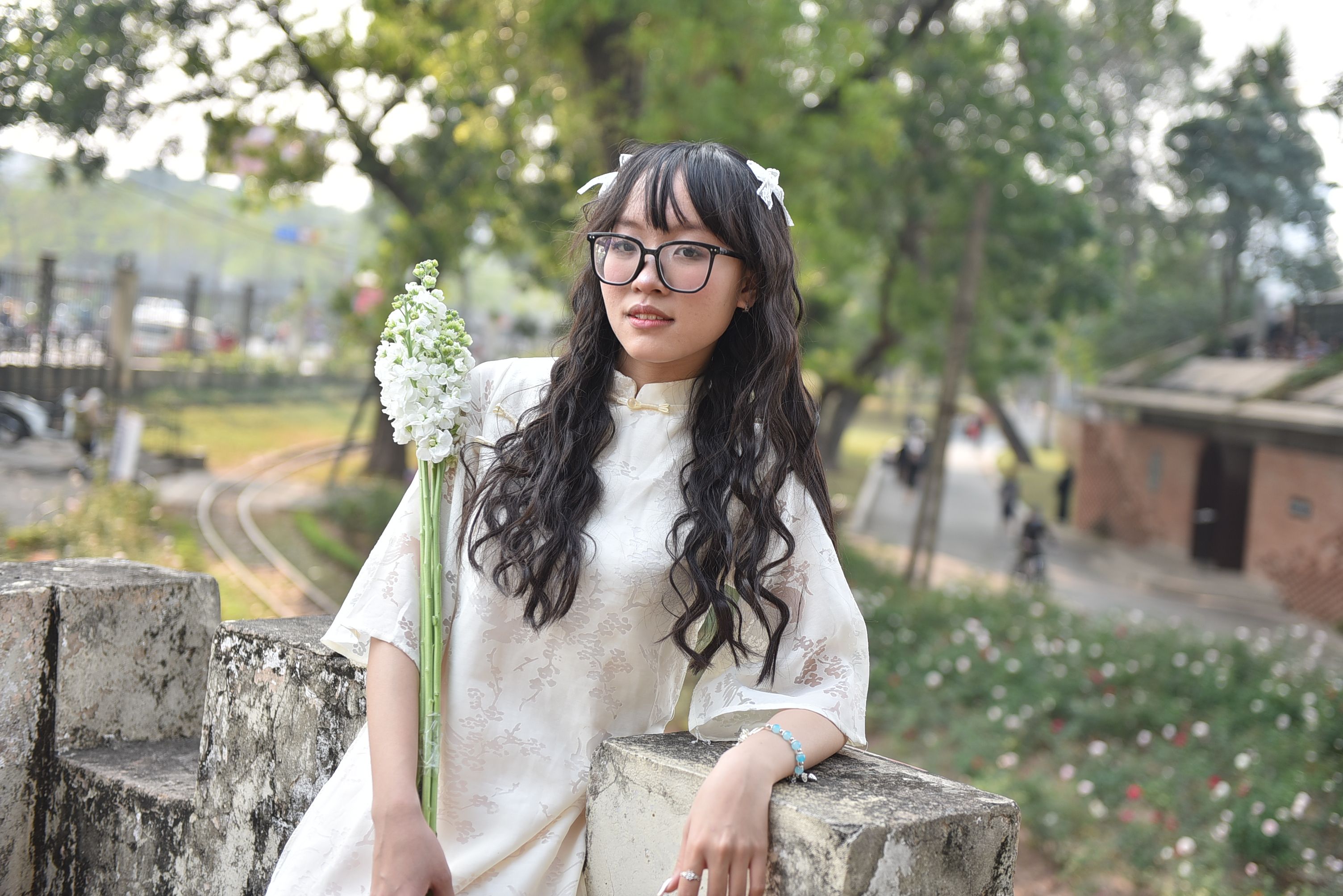 Young woman in traditional dress holding flowers outdoors · Free Stock ...