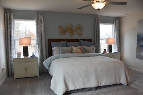 Gratis Elegante dormitorio con decoración moderna, cuenta con cama, lámparas y elementos de arte. Foto de stock