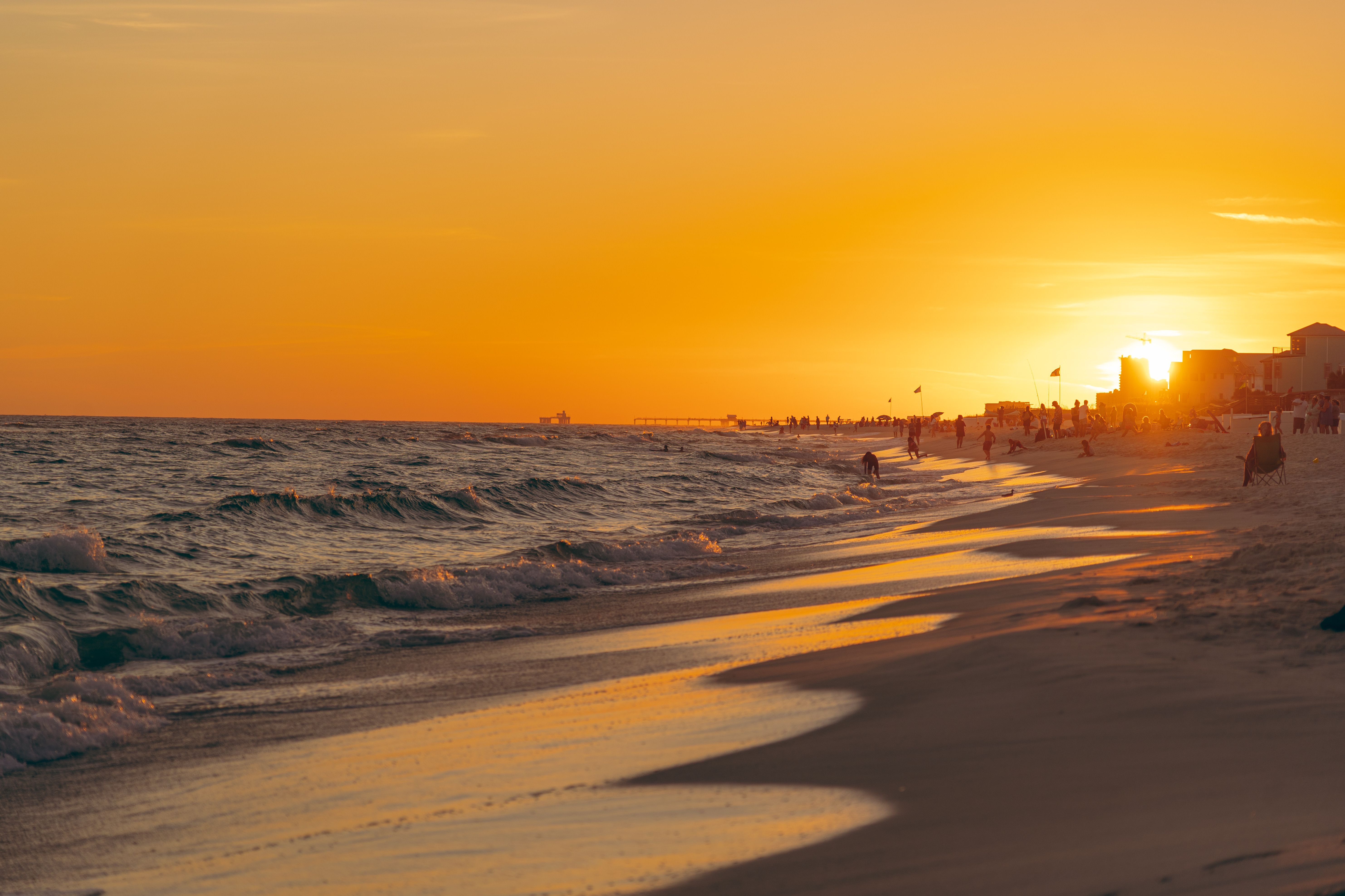 Sunset Beach Scene with Waves and Silhouettes · Free Stock Photo