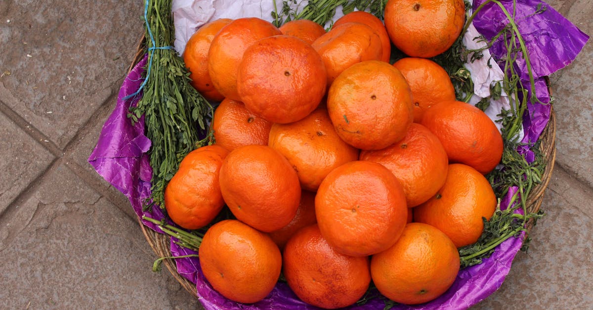 A colorful basket of fresh tangerines on a market floor, vibrant and appetizing.