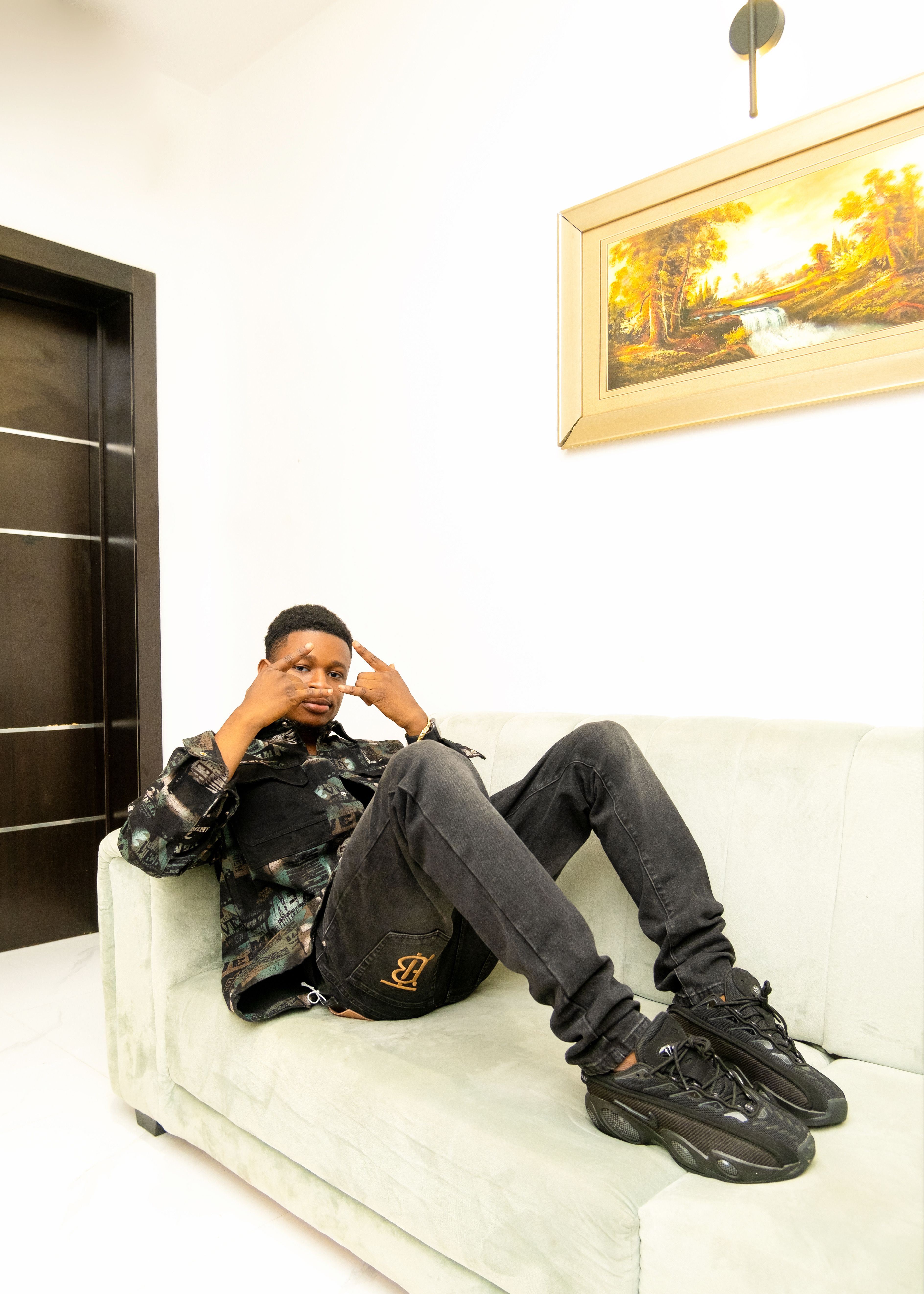 A laid-back moment featuring a man reclining on a sofa in a bright interior.