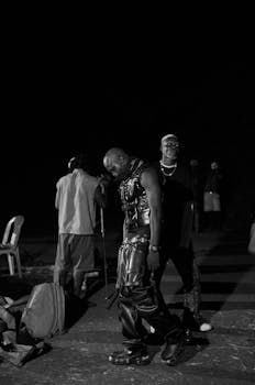 Group of fashionable individuals gathered outdoors at night in a candid street scene.