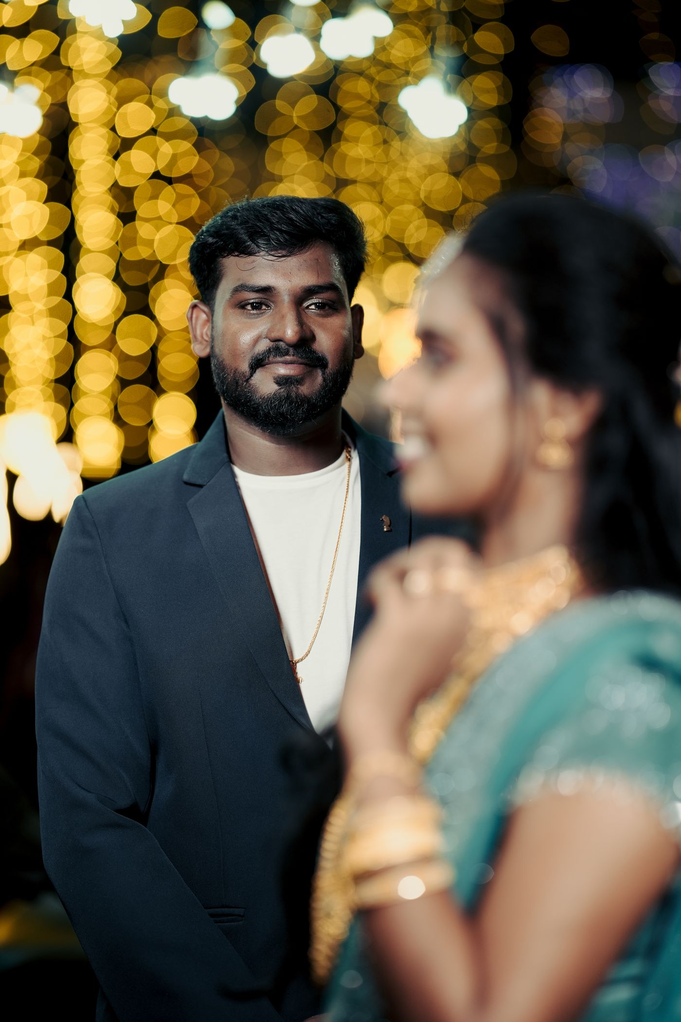 An Indian wedding portrait glowing with warm bokeh lights.