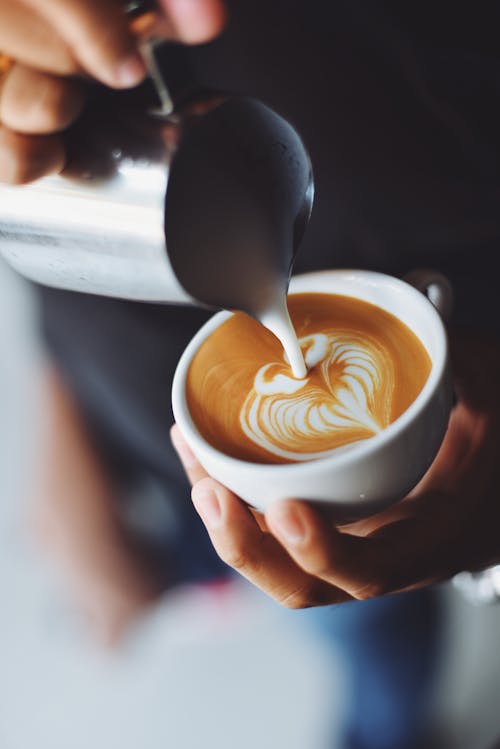 カプチーノを注ぐ女性