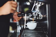 镜头特写：咖啡师在咖啡馆用咖啡机制作浓缩咖啡