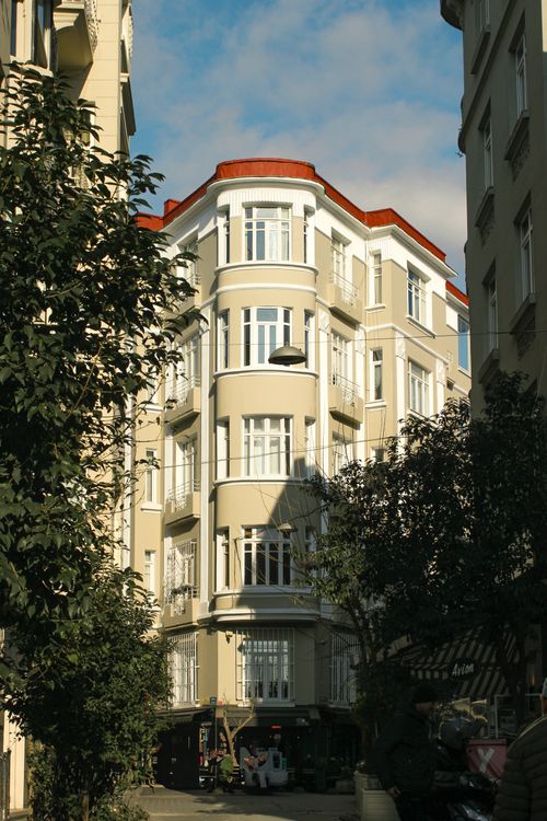 Free Elegant corner building with ornate architecture and red roof in sunny European city. Stock Photo