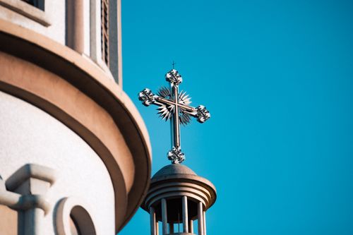 Free Close-up of an ornate cross atop a church tower in Addis Ababa under a clear blue sky. Stock Photo
