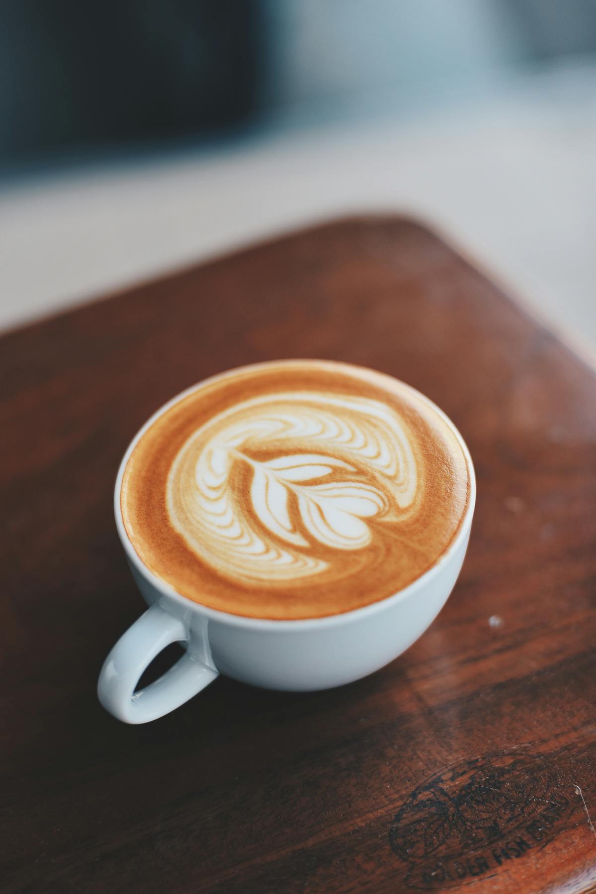 Barista pouring latte art into a cup of coffee
