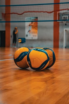 Three volleyballs on a sports court in Kyiv, Ukraine. Ideal for athletic and sports themes.