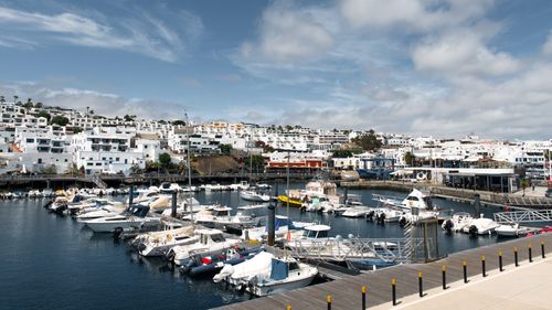 Free Scenic view of a marina with boats and white buildings in Lanzarote, Canary Islands. Stock Photo