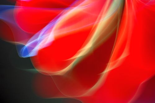 Free Abstract image featuring dynamic red, blue, and yellow light streaks. Stock Photo