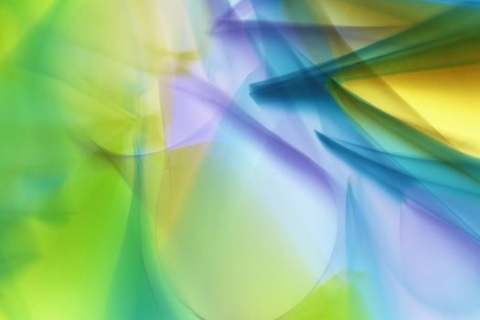 A dynamic abstract image featuring vivid blues, greens, and yellows in a fluid composition.