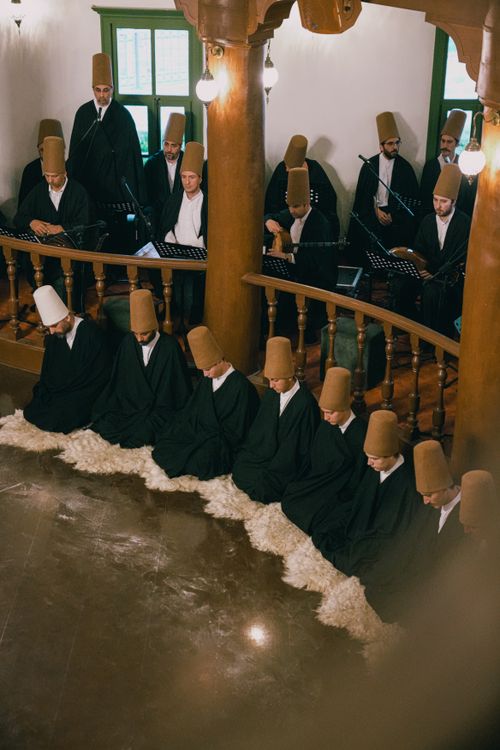 Free Whirling dervishes in traditional attire performing a Sufi ritual in Bursa, Türkiye. Stock Photo