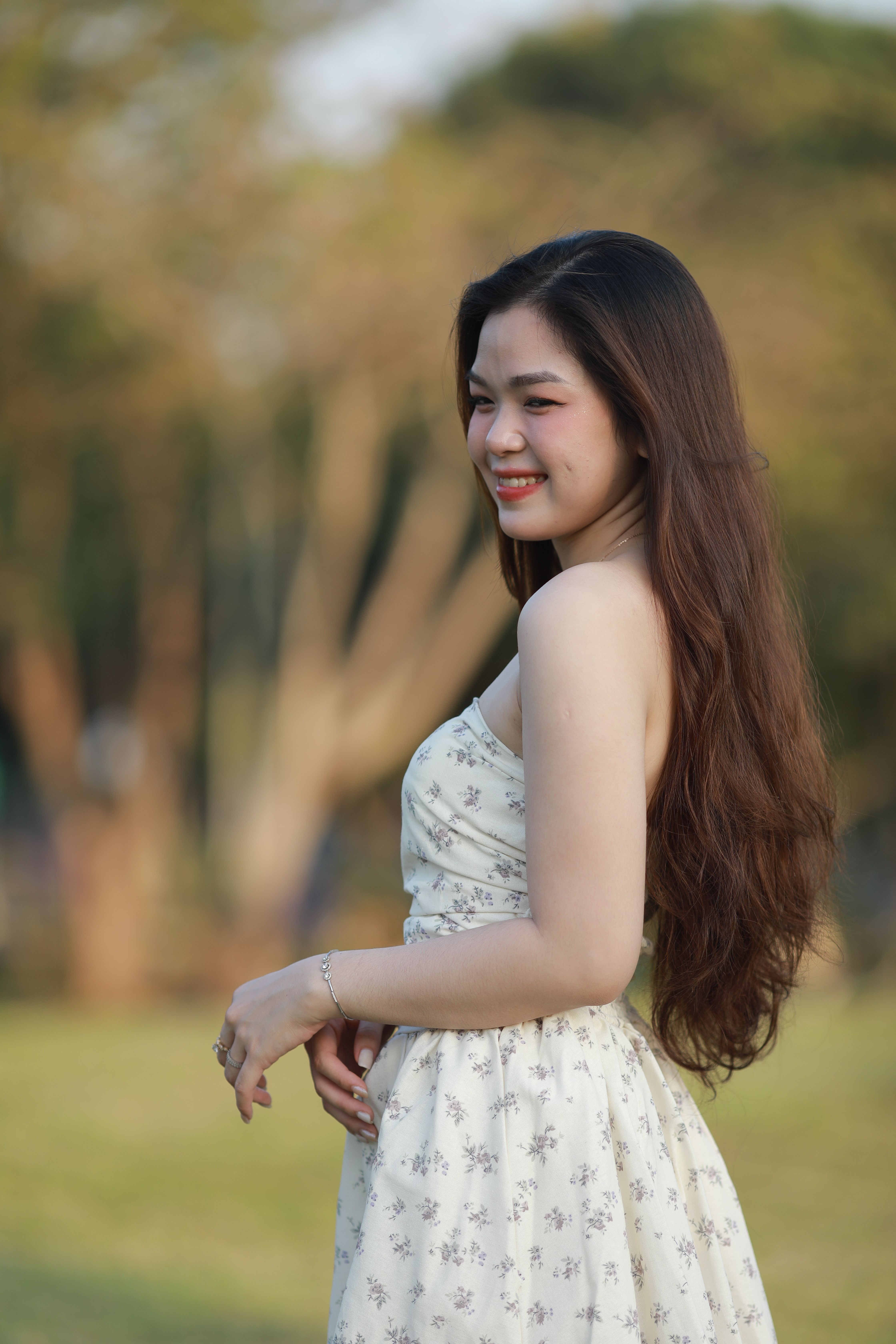 Smiling Woman in Floral Dress Outdoors · Free Stock Photo